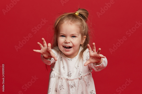 Portrait of a child. funny little girl on studio red background