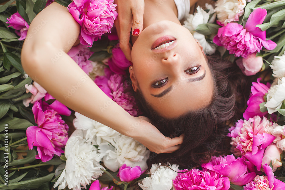 Close up portrait of young beautiful woman with flowers indoors