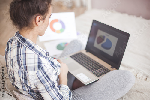 Young attractive woman working at laptop photo