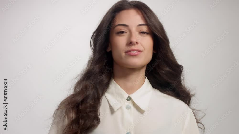 Closeup portrait of a brunette woman with long shiny hair. Panned portrait slightly smiling woman Closeup portrait of a brunette woman with long shiny hair. Panned portrait slightly smiling woman