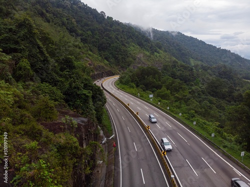 Scenic aerial view of “Lebuhraya Utara-Selatan”, a highway located in Malaysia. Highway surrounded by forest, winding road © MuhammadFadhli