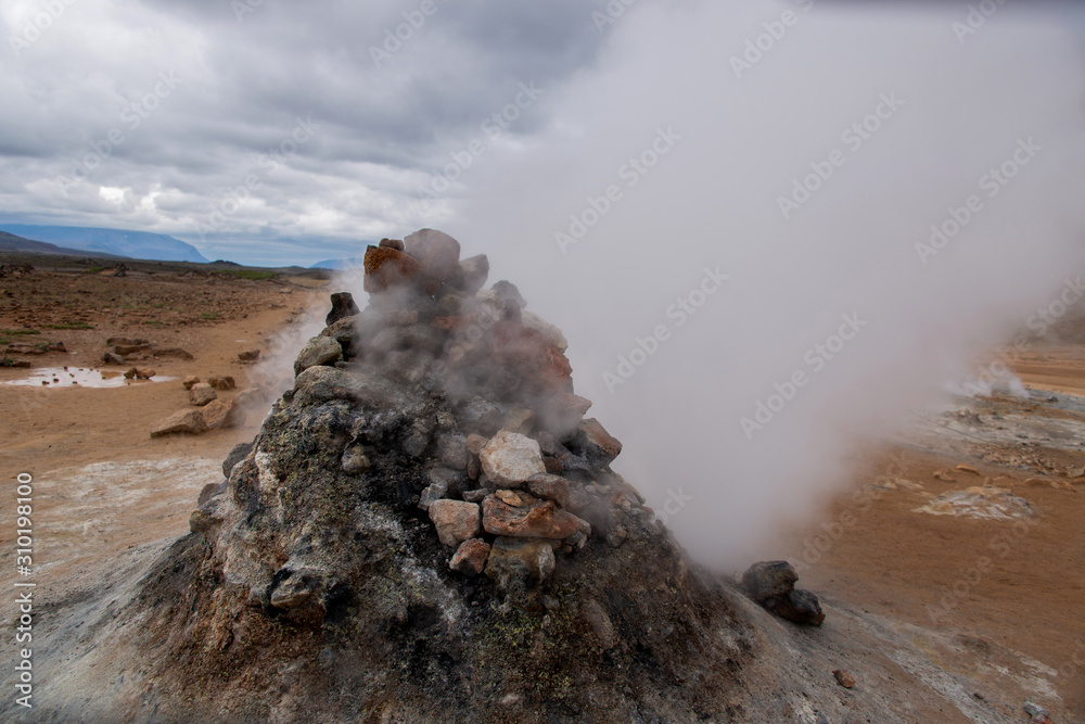 Vulkanlandschaft auf Island, heißer Wasserdampf entweicht Steinhaufen