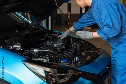 Technicians are checking the condition of the car according to the month. The technician uses the tablet to check.