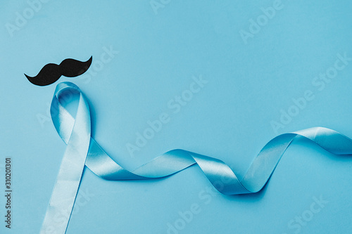 Top view on Light blue ribbon with mustache on blue background. Prostate Cancer Awareness, Movember Men's health awareness, November Blue, International Men's Day photo