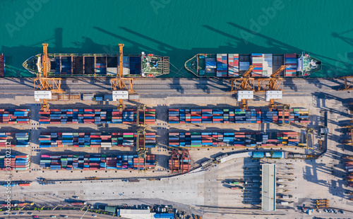 Aerial top view container cargo ship at Terminal commercial port and working crane bridge loading container for business logistics, import export, shipping or transportation.