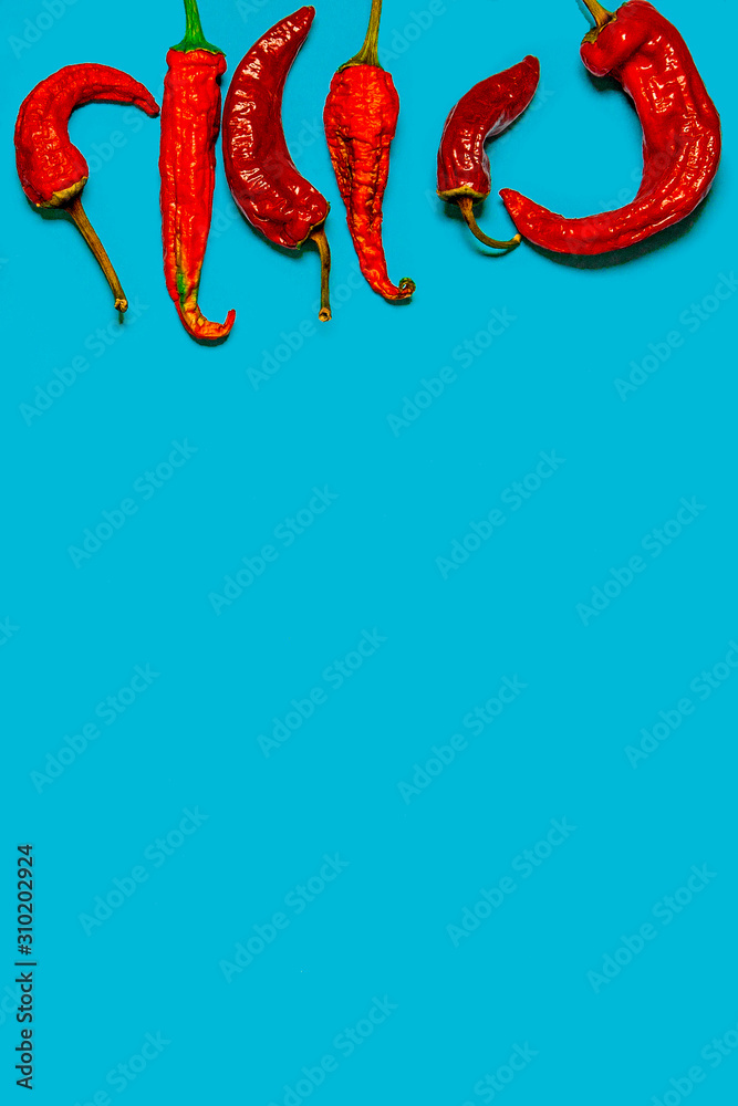 Dried red chili peppers lie on a multi-colored background Dried red chili peppers lie on a multi-colored background