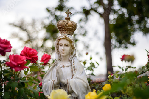 Virgin Mary in a garden with colorful roses at Santa Fe, New Mexico