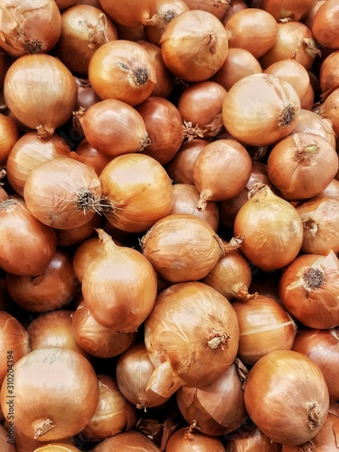 bulbs of usual onions as a background (top view) at the market