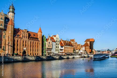 View of old town Gdansk (Gdańsk / Danzig), Poland (Polska / Polen) with merchants' houses, and historic medieval Crane (Żuraw / Krantor). Beautiful calm morning on the Motlava (Motława) River.
