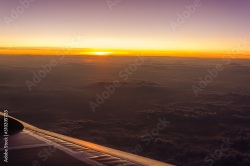 sunrise from the porthole of an airplane