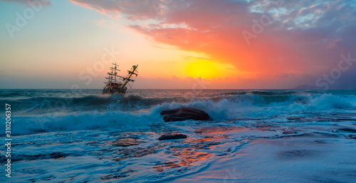 Sailing old ship in stormy sea in the background dramatic sunset "Elements of this image furnished by NASA" © muratart