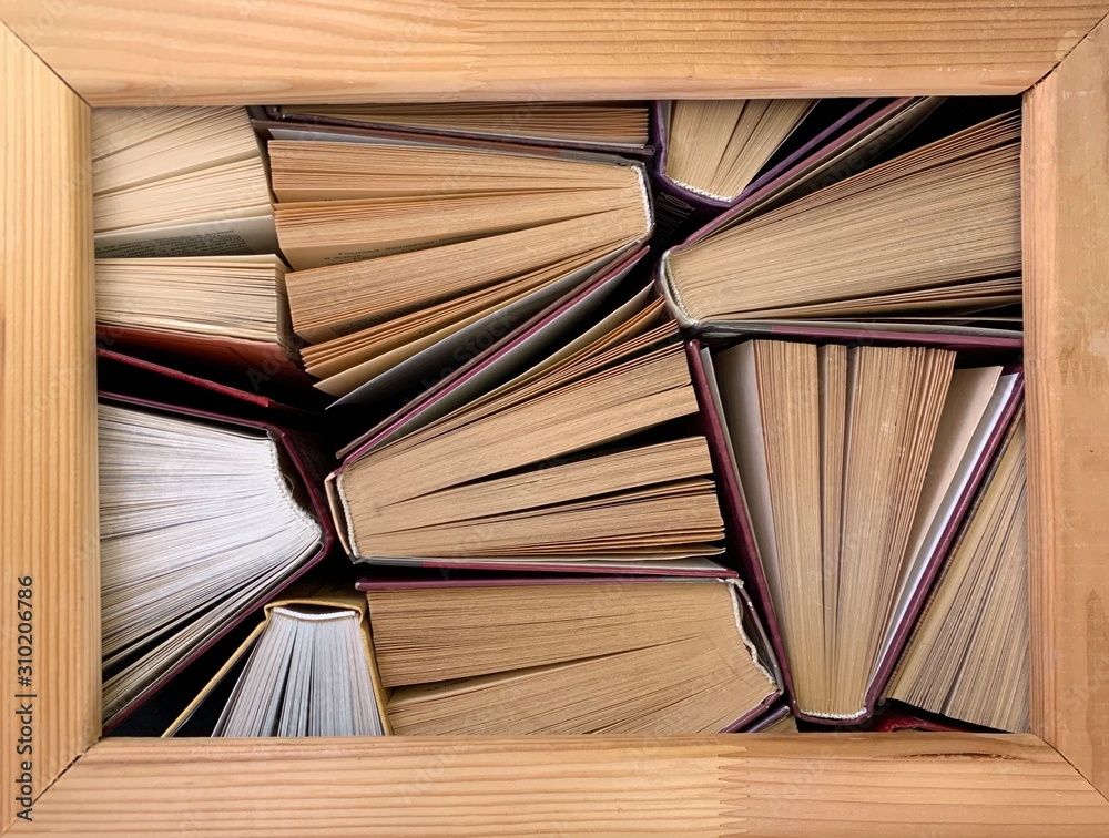 Fototapeta premium Background texture: ajar pages of books. Old hardback textbooks, on black background. Concept: education, self-improvement, personal growth.