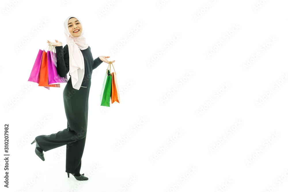Portrait of beautiful asian muslim woman in a black hijab holding multi-colored shopping bags in her hand religion Islam shopping on white background Portrait of beautiful asian muslim woman in a black hijab holding multi-colored shopping bags in her hand religion Islam shopping on white background