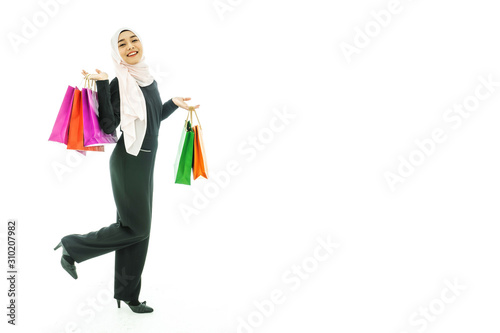 Portrait of beautiful asian muslim woman in a black hijab holding multi-colored shopping bags in her hand religion Islam shopping on white background
