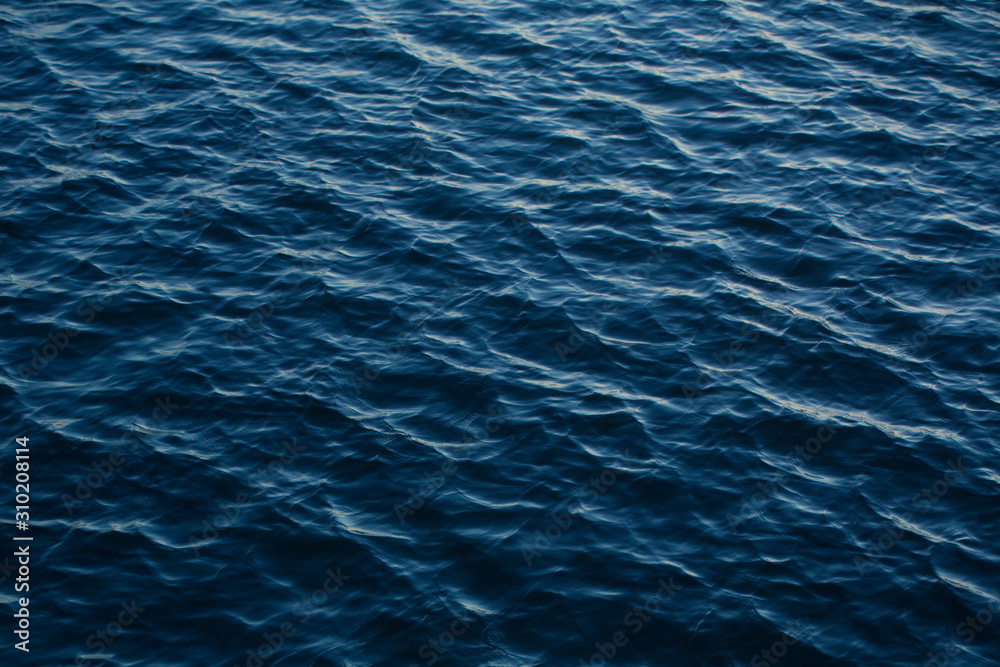 Infinite background of water waves in lake. Blue to black colors. Natural texture. Infinite background of water waves in lake. Blue to black colors. Natural texture.