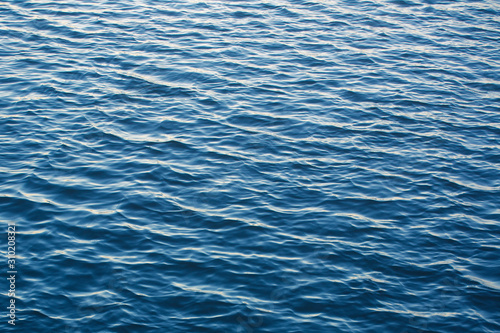 Infinite background of water waves in lake. Blue to black colors. Natural texture. © Martin