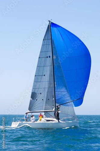 Yacht With Blue Sail Competes In Team Sailing Event