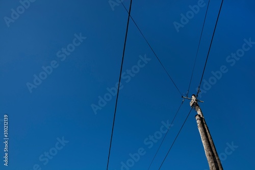 Low angle view of electric wires against clear blue sky