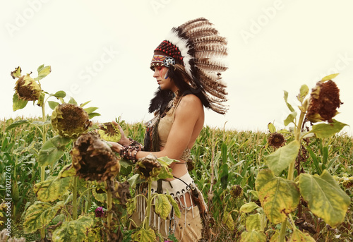 Fotografie An Indian girl is seen in a dried out crop field