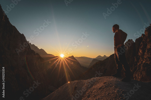 Hiker watching the beautiful sunset in a scenic mountain range