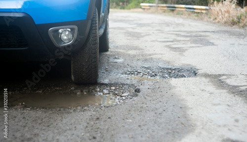 car tire in damaged road with hole in the asphalt. accident or maintenance concept