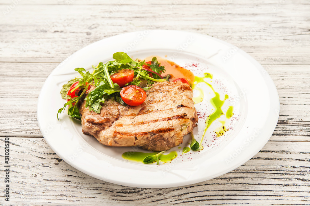 Chicken fillet in a restaurant close-up. Wild duck fillet with vegetables on a white plate and copy space. Chicken fillet in a restaurant close-up. Wild duck fillet with vegetables on a white plate and copy space.