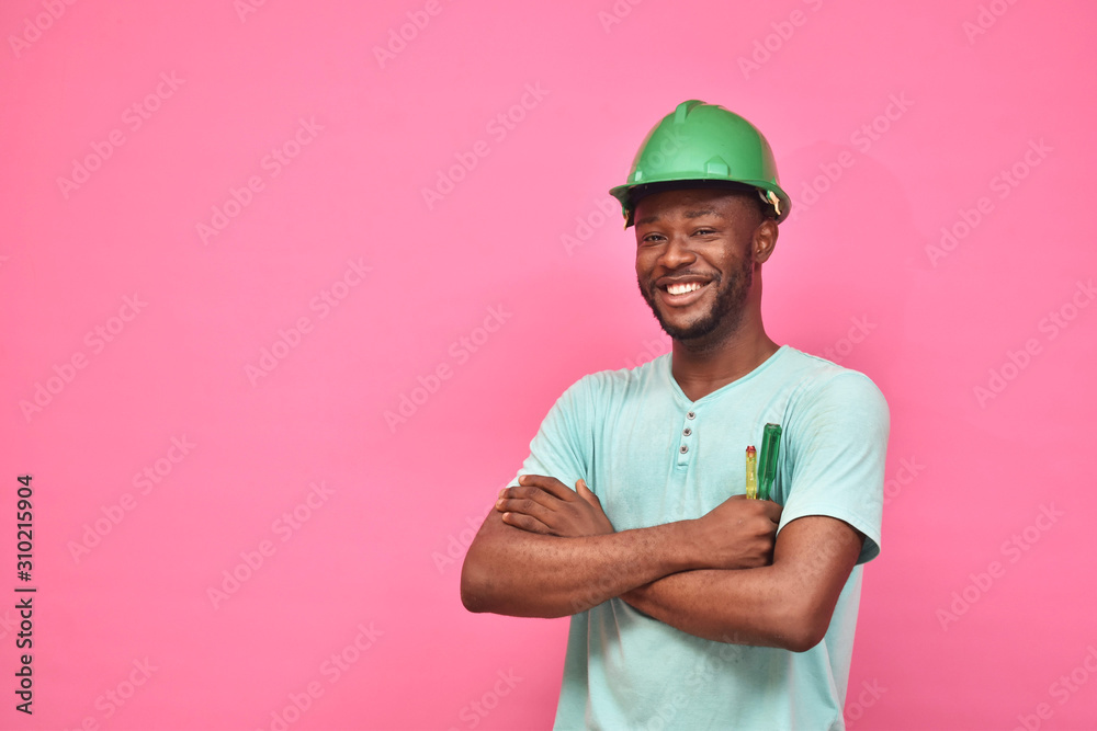 handsome excited young black man wearing a hard hat and holding a screwdriver feeling excited giving thumbs up gesture