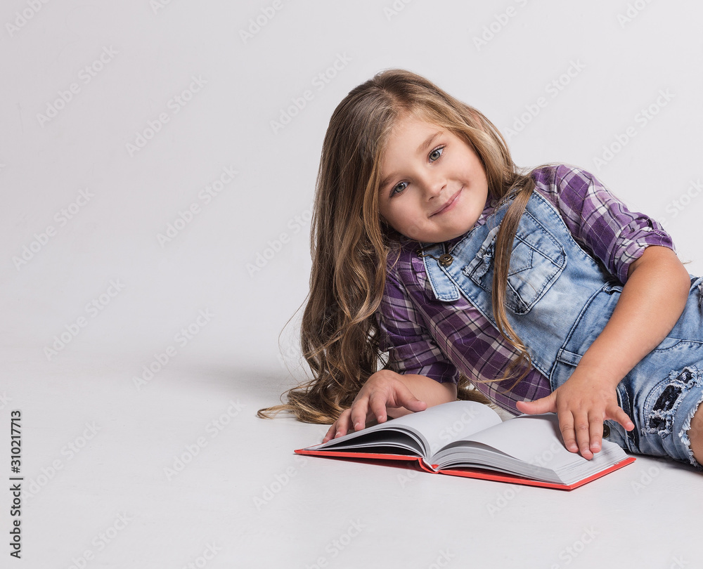 Beautiful little girl reading and lying Beautiful little girl reading and lying