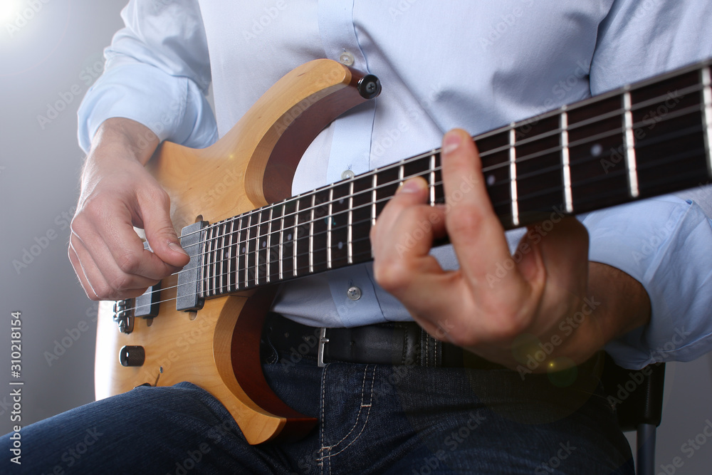 Male arms playing classic shape electric guitar