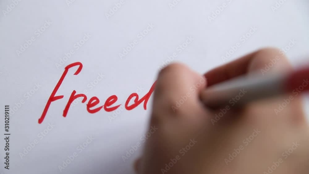 Hand writing freedom on white paper Hand writing freedom on white paper