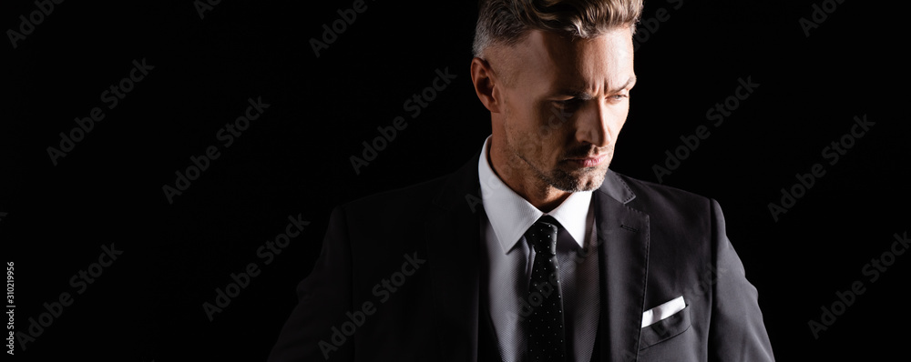 Panoramic shot of handsome businessman looking away isolated on black - obrazy, fototapety, plakaty 