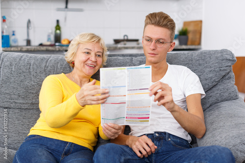 Mother and her adult son reading brochure
