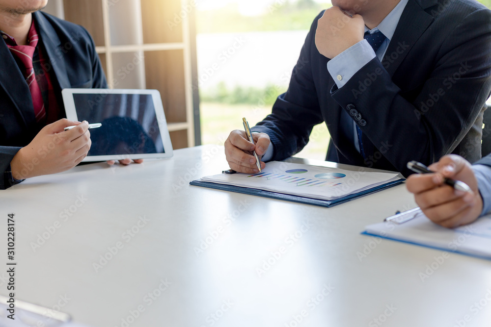 Business people gather to analyze marketing and investment information and using pen pointing to financial data chart at meeting. Business people gather to analyze marketing and investment information and using pen pointing to financial data chart at meeting.