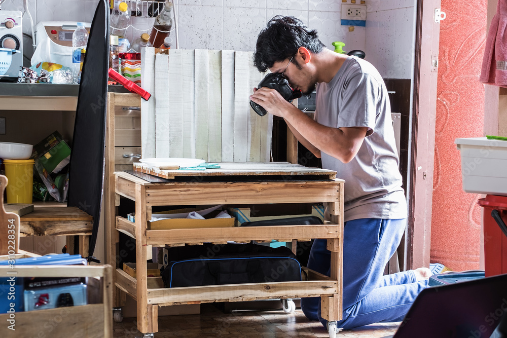 Professional photographer taking a photo with simple natural light studio set up inside kitchen in a narrow space.