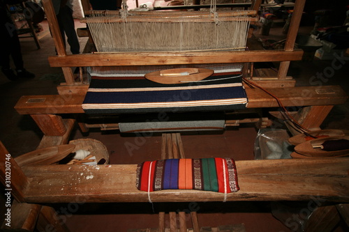 Old fashioned loom with woven blanket in progress photo
