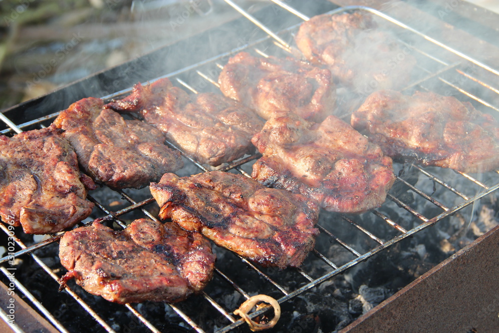 Process of cooking meat. Steak on barbecue. Preparation appetizing pork outside Process of cooking meat. Steak on barbecue. Preparation appetizing pork outside