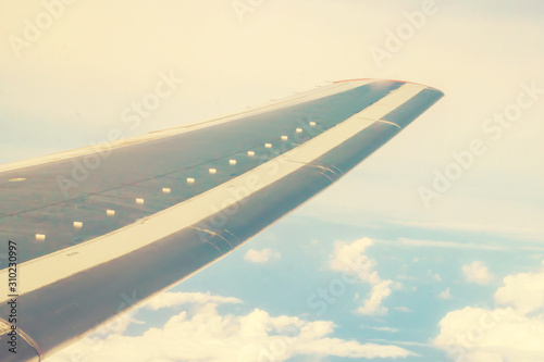 View of clouds and sky. aircraft wing from the window, tinted photo