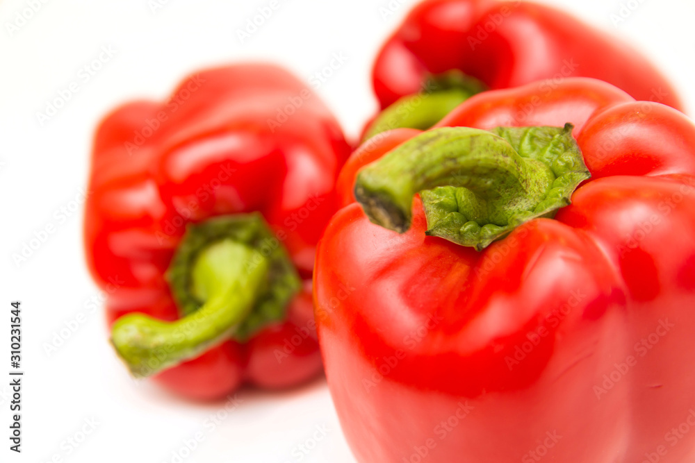 Ripe and delicious red bell peppers or paprika isolated over white background. Organic and healthy food concept. Agriculture and harvest. Vegetarian food. Supermarket banner. Selective focus. Ripe and delicious red bell peppers or paprika isolated over white background. Organic and healthy food concept. Agriculture and harvest. Vegetarian food. Supermarket banner. Selective focus.