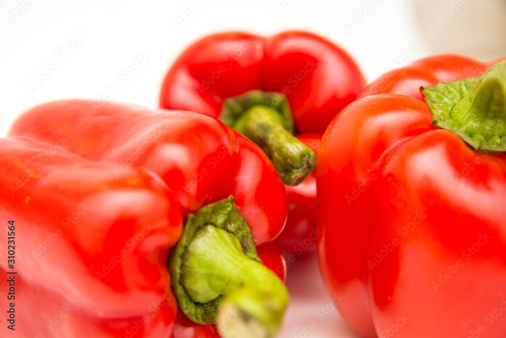 Ripe and delicious red bell peppers or paprika isolated over white background. Organic and healthy food concept. Agriculture and harvest. Vegetarian food. Supermarket banner. Selective focus. Ripe and delicious red bell peppers or paprika isolated over white background. Organic and healthy food concept. Agriculture and harvest. Vegetarian food. Supermarket banner. Selective focus.