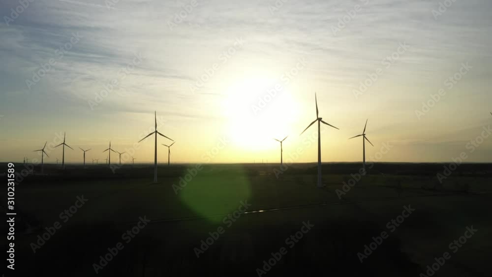 Windpark im Sonnenuntergang zur Erzeugung von regenerativer Energie für E-Mobilität - Luftaufnahme Windpark im Sonnenuntergang zur Erzeugung von regenerativer Energie für E-Mobilität - Luftaufnahme