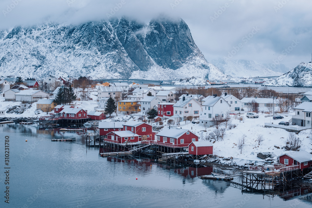 Fototapeta premium Red Rorbuer houses in Lofoten Islands, Northern Norway. Snowy landscape