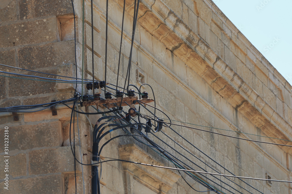 Messy electrical cables on wall corner in Malta