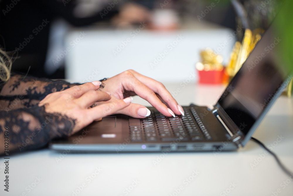 closeup of female hands typing on laptop