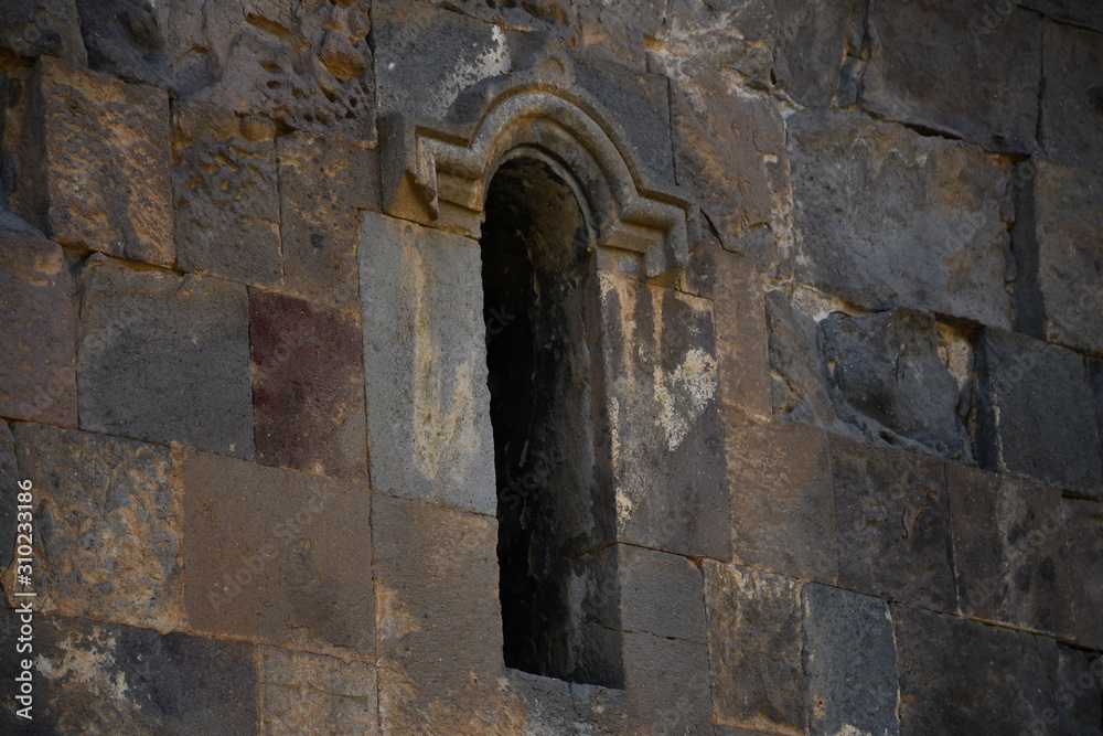 wall of a medieval church in Armenia. basalt window in a medieval church. basalt background and texture. gray texture. ancient masonry walls.