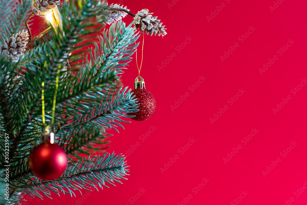 Christmas background with fir tree, frame of twigs christmas tree, brown pine cones on red background with space for text