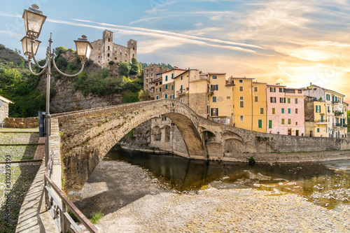 The colorful hilltop, medieval village of Dolceacqua, Italy, with it's famous castle and stone Monet bridge as the sun sets. photo