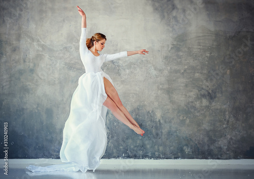 Fototapeta Naklejka Na Ścianę i Meble -  beautiful russian girl dancing in white in the studio