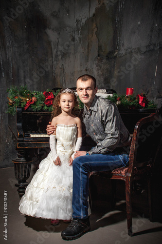 father and daughter at the piano with Christmas decor