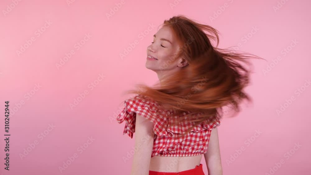 Happy beautiful young woman on pink background. Slow motion effect Happy beautiful young woman on pink background. Slow motion effect