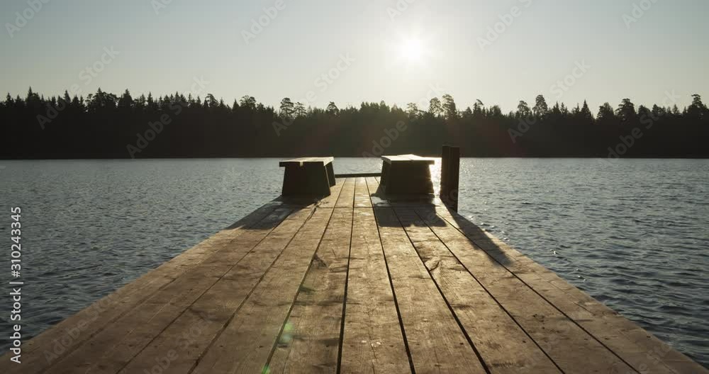 Wooden swimming jetty on lake in sunny morning